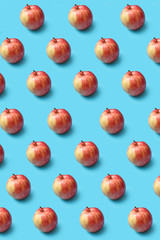 Wall Mural - Creative pattern from fresh organic red apples on a blue background.