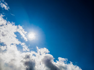 blue sky background with clouds and rays of the sun.
