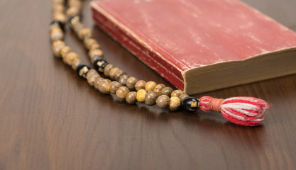 Poster - Muslim prayer beads and Koran isolated on a wooden background. Islamic and Muslim concepts