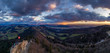 © alexander - Tourists on a hiking route at the top of the mountain in Jura mountains conteemplating dramatic sunset and colorful rain over the Swiss Central Valley in January with Alps mountains on the horizon