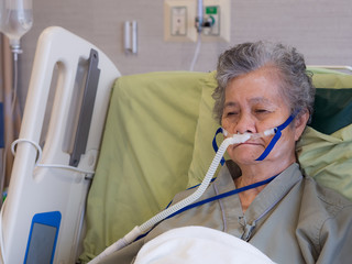 close-up of elderly woman patient with lung disease, getting oxygen for treatment in the room at hos