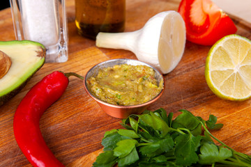 sauce and ingredients included in it on a wooden board