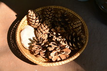 High Angle View Of Pine Cones In Wicker Basket On Table