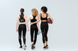 © LIGHTFIELD STUDIOS - back view of multicultural girls walking with sport equipment on white
