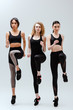 © LIGHTFIELD STUDIOS - beautiful and multicultural women in sportswear exercising on white