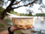 Fototapeta  - eco friendly  Organic bagasse bowl for single used in hand on blur background;