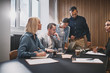 © Flamingo Images - Businesspeople working on a laptop during a boardroom meeting