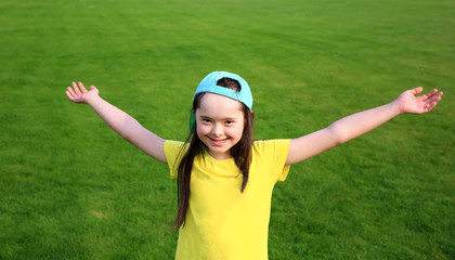 Wall Mural - Young girl on the background of green grass