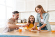 © Drobot Dean - Photo of happy family eating croissants while having breakfast