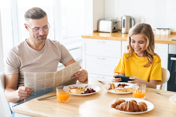 Sticker - Photo of funny father and daughter using cellphone and reading newspaper