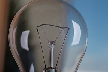 Light bulb on a background of blue sky. Electricization concept. Earth Day. Earth Hour.