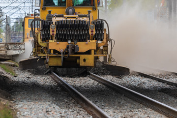 A huge dust cloud in the center of a big city during the operation of the auxiliary railway machine. Reconstruction of the railway line.