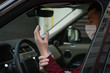© Evghenii Blanaru - a man driving in medical mask in car puts medical gloves on a  during an epidemic, a taxi driver in a mask, protection from the virus. Driver in black car. coronavirus,infection, quarantine, covid-19