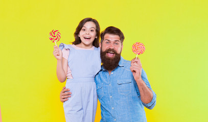 Happy all day. Happy family yellow background. Happy father and daughter eat lollipops. Candy shop. Having fun. Being positive. Leisure and rest time. Enjoying time together. You make me happy