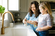 © Jessica Peterson/Tetra Images - Mother and daughter washing hands in kitchen sink