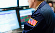 © Tetra Images - Stock trader with american flag on sleeve