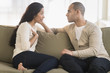 © Tetra Images - Young couple sitting on couch