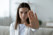 © fizkes - Close up of young woman show stop gesture sign by hand saying no to domestic violence or abuse, determined millennial female protest against abortion or discrimination, nonverbal language concept