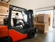 © Erik Isakson/Tetra Images - Forklift truck loading pallets into trailer