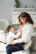 © innarevyako - Young pregnant woman posing with her little son in the interior. Cute little baby boy playing with his mom at home. Cheerful family. Expecting baby