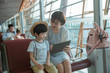 © View Stock - A young mother and son in the airport lounge see tablets