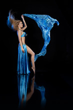Young Woman Belly Dancer In A Blue Oriental Costume On A Black Background