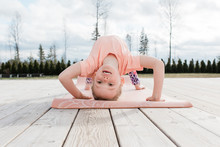 Young Girl Doing Gymnastics And Yoga In Her Back Yard At Home