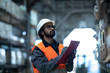 © Cavan Images - Young man checking materials in warehouse