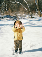 A Little Boy With Cold Hands On A Snowy Winter Day.