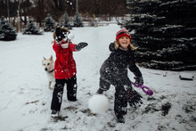 Siblings Playing With Snowballs Outdoors