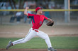 © Cavan Images - teen baseball player pitcher in red uniform in full wind up on the mound