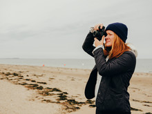 Woman Taking Photos On Beach In Scotland