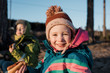 © Cavan Images - portrait of a young girl eating a hot dog by a campfire in Sweden