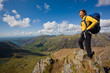 © Cavan Images - Woman overlooking Snowdonia National Park while standing on rock