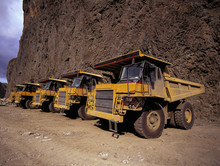 Yellow Dump Trucks Parked At Side Of A Cliff