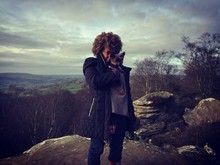 Portrait Of Woman With Yorkshire Terrier Standing At Brimham Rocks Against Sky