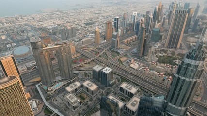 Wall Mural - Urban road junction at Dubai city, UAE. Downtown panorama of skyscrapers and modern buildings of Dubai business district at sunrise, view from above