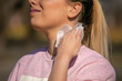 Young woman clean face and neck with wet wipes outdoor, remove sweat