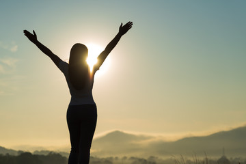 Wall Mural - Silhouette of happy woman spreading arms and watching the mountain. Travel Lifestyle success concept adventure active vacations outdoor freedom emotions.