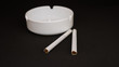 two cigarettes with an ashtray on a black background