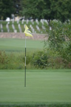 A Yellow Golf Hole Flag Blows In The Wind On A Golf Course On A Sunny Summer Afternoon 