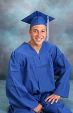 Young Man In Cap And Gown Poses For A Graduation Portrait 