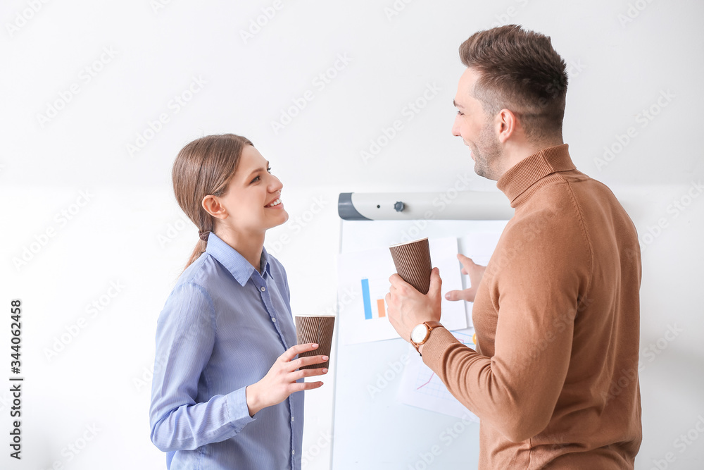 Young colleagues drinking coffee in office