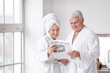 © Pixel-Shot - Mature couple reading newspaper in bathroom
