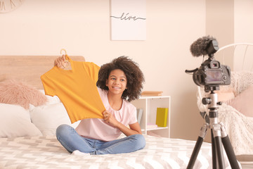 Wall Mural - African-American teenage fashion blogger recording video at home