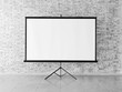 © Pixel-Shot - Modern projector screen near brick wall indoors