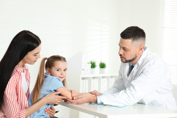 Wall Mural - Little girl with mother visiting orthopedist at clinic