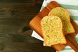 Two Garlic Butter Toasts on Wooden Plate Served on Dark Brown Table with Napkin