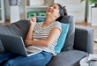© gpointstudio - Young Asian woman laughing during a video conversation at home.