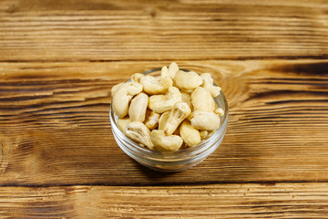 Poster - Glass bowl with raw cashew nuts on a wooden table